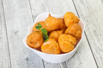 Sweet tasty profiteroles heap in the bowl