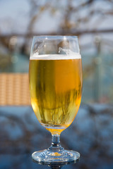 A Glass of Chilled Beer Outdoors on a Table 