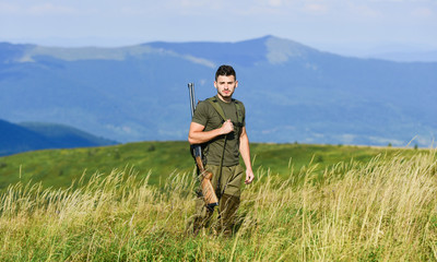 Naklejka na ściany i meble there is safety in numbers. hunter hobby. military style. male in camouflage. muscular man hold weapon. purpose and success. army forces. sniper reach target mountain. soldier in the field. polygon