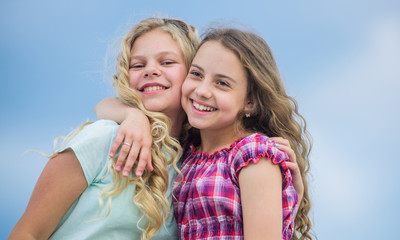 Curly and gorgeous hairstyles. Beautiful sisters. Hairdresser salon services. Two little girls kids with long curly hair. Girls with healthy natural curly hair. Beauty procedure. Adorable kids