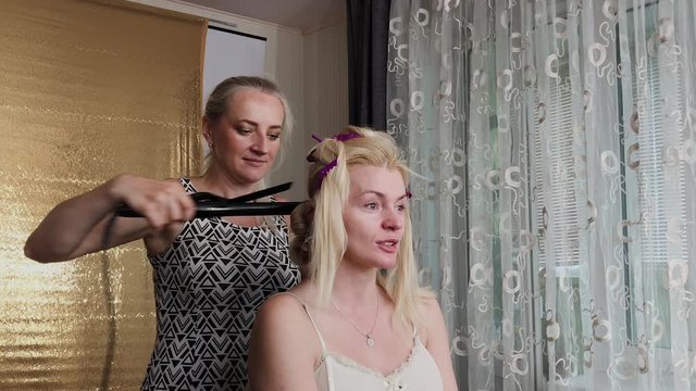 Professional hairdresser woman doing hairstyle photo of model.