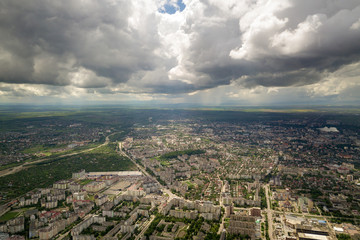 Aerial view of town or city with rows of buildings and curvy streets in summer. Urban landscape from above.