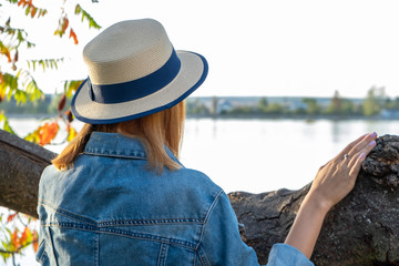 Fototapeta premium Portrait of teenage girl in yellow hat and with red hair wearing geans jacket outdoors on sunny autumn day.