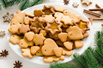Fototapeta na wymiar Plate full of freshly baked Christmas gingerbread on white wooden background.