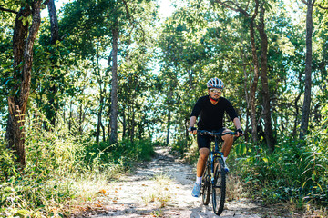 Naklejka premium The man riding a bike in a mountain path