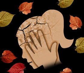  Autumn sadness and depression, young woman. Stylized male head silhouette holding his head.Photo-montage with Dry cracked earth and autumn leaves symbolizing Depression.