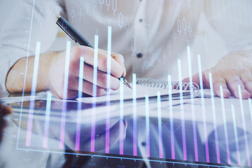 Multi exposure of man planing investment with stock market forex chart.