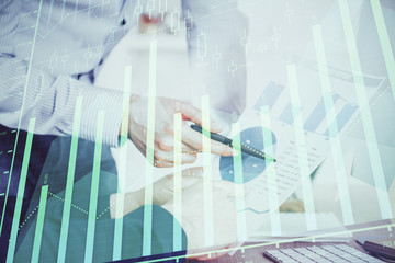 Financial trading graph double exposure with man desktop background.