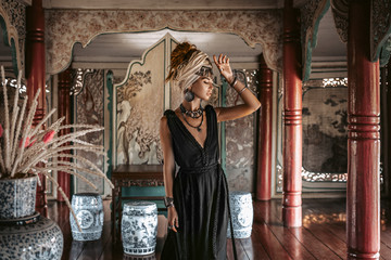 beautiful young woman in elegant black dress wearing turban. oriental princess