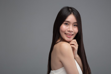 Fototapeta premium Woman wearing a white strapless dress and hands touching the chin.