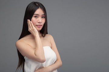 Fototapeta premium The woman wore a white strapless dress and hands touch her face.