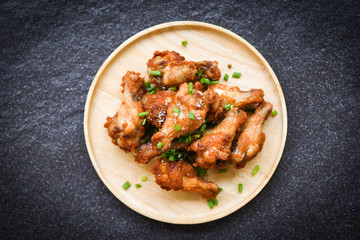 Fried chicken wings on wooden plate with salt and spring onion , top view - Baked chicken wings BBQ , wings crispy