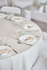 Plates with glasses on a table with a white tablecloth