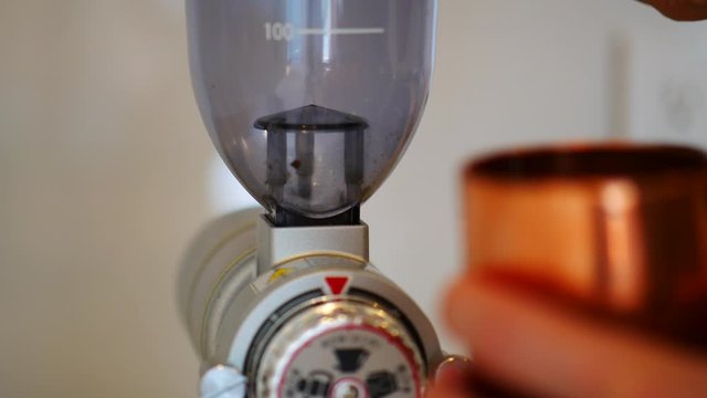 コーヒー豆を機械に入れて計量する