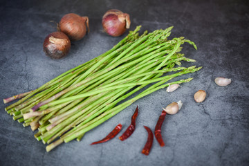 Obraz na płótnie Canvas Fresh asparagus bunch on dark background - Asparagus green with chilli garlic and shallot for cooking food