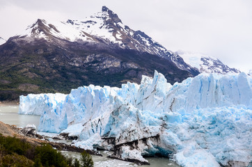 Huge glacier in Patagonia Argentina with snowy mountain on a cloudy day - Perito Moreno	