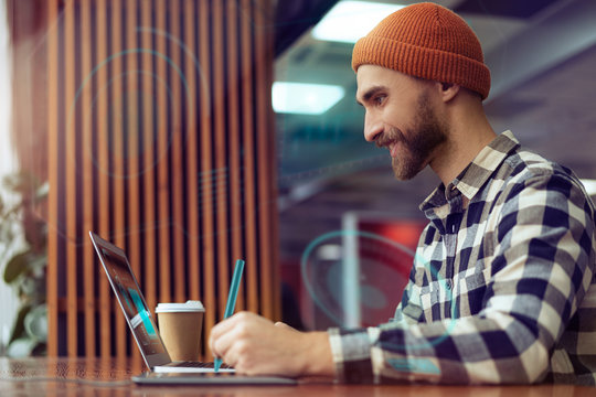 A graphic designer is working with a holographic environment hud surrounding him, projecting his creations over his augmented reality digital user interface. Communicate about future creative business