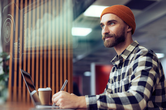 A graphic designer is working with a holographic environment hud surrounding him, projecting his creations over his augmented reality digital user interface. Communicate about future creative business - Powered by Adobe