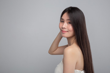 Fototapeta premium That woman wore a white strapless dress and her hands touch her hair.