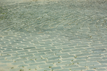Antique paving stones. Grey boulders, old architecture, top view on the road.