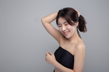 The woman wearing black strapless tops and hands touch her hair.