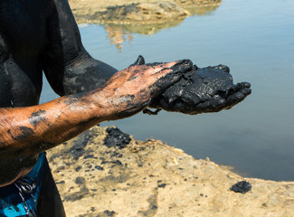 Man applying black healing clay