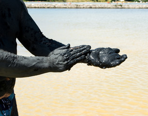Man applying black healing clay