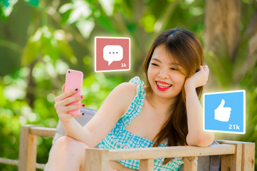 lifestyle portrait of young happy and attractive Asian Chinese woman using internet mobile phone composite with social media app likes and chat comments icons