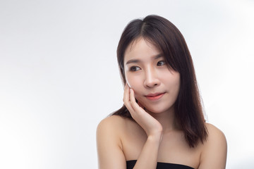 The woman wore a black strapless dress and hands touch her face.