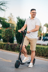 Portrait of a hipster man on a electric scooter.