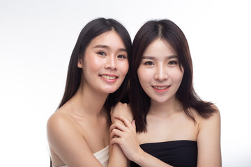 Two young women happily stood together from behind.