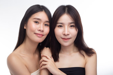 Two young women happily stood together from behind.