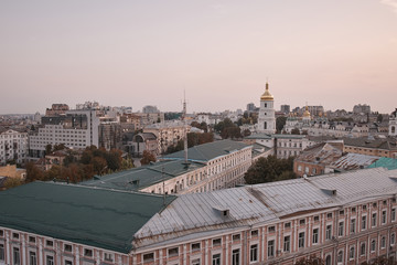 Obraz premium View overlooking the town. Kiev view into the distance to the city. Houses and buildings. Roofs of buildings. Cathedral in the city center. Streets, roof, houses, structures, a trip to Europe