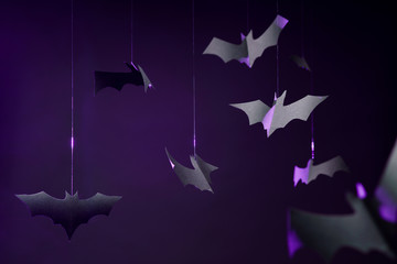 Photo of gray paper bats on empty purple background.