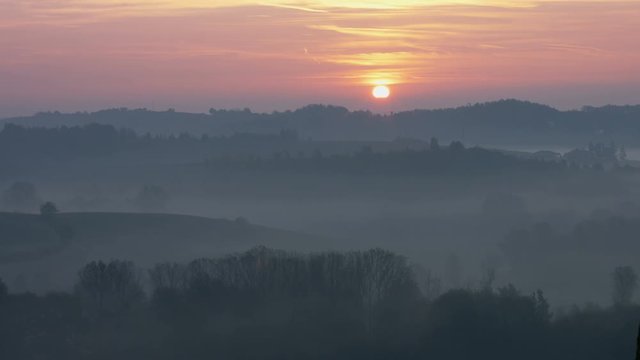 Magic morning sunrise over hills covered by fog in fall