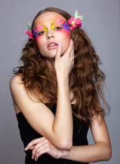 Portrait of teen girl with orchid flower in wavy hair.