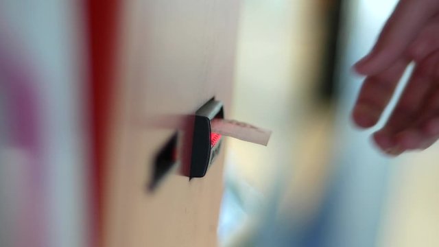 Man put banknote to bill acceptor of vending machine. Ten Ukrainian cash hryvna