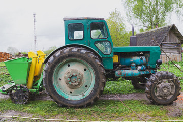 Old tractor in the village in early spring