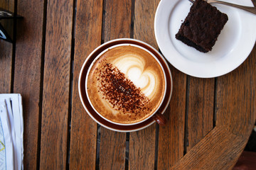 Table setting with a cup of barista coffee and browny cake