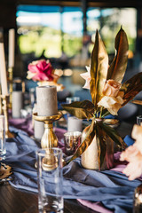 Obraz na płótnie Canvas details of serving on a banquet.Luxurious decor on the wedding table. candles, flowers, gold and blue elements