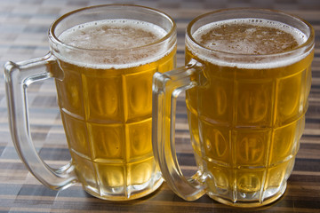 Two Mugs of Chilled Beer on a Table