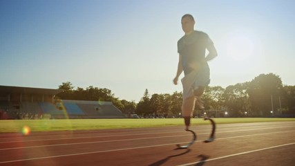 Athletic Disabled Fit Man with Prosthetic Running Blades is Training on a Outdoors Stadium on a Sunny Afternoon. Amputee Runner Jogging on a Stadium Track. Motivational Sports Footage. Tracking Shot. - Powered by Adobe