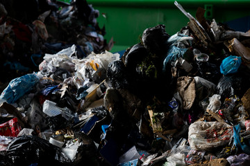 Truck tipping garbage from container on junk yard