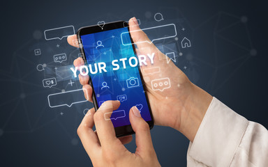 Female hand typing on smartphone with YOUR STORY inscription, social media concept