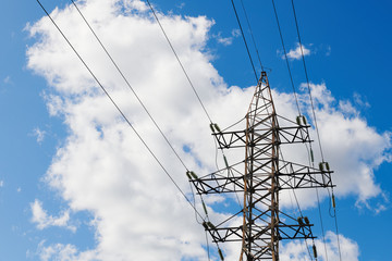 Power transmission line pole against blue cloudy sky. Support pole for high voltage. Sunny day. Large size photo.