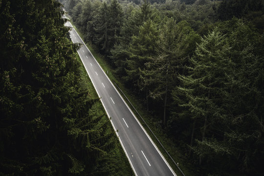 Gerade Stra&szlig;e durch dicht bewachsenen Wald in Nordrhein Westfalen