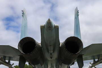 The tail of a military fighter and its two large jet engine nozzles