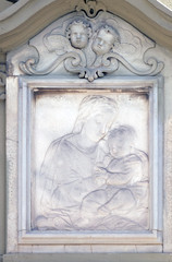 Fototapeta na wymiar Virgin Mary with baby Jesus, relief on the house facade in Florence, Italy