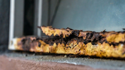 Close up view of the old rusty window fence. Damaged, broken and rotted of fence metal.