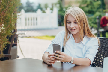 Portrait of a pretty young girl with a phone, smiling closeup